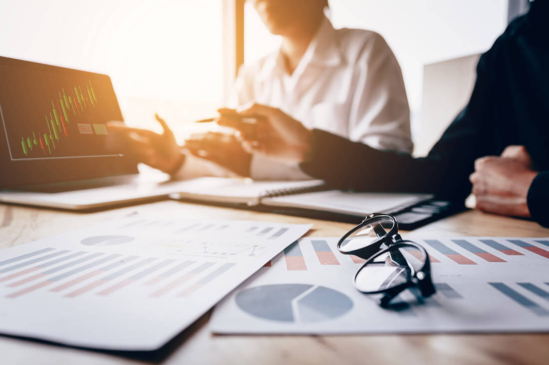 colleagues using a laptop together and analyzing a graph